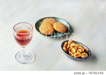 A glass of sweet wine with biscuits and nuts A glass of sweet wine with biscuits and nuts 76782348