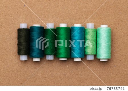 Many colored spools of threads as a background 76783741