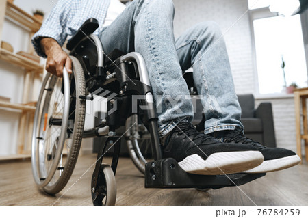Unrecognizable disabled man sitting in a wheelchair Unrecognizable disabled man sitting in a wheelchair 76784259