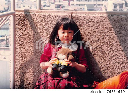 昔のフィルム写真 うさぎのぬいぐるみと双眼鏡をもった女の子の写真素材