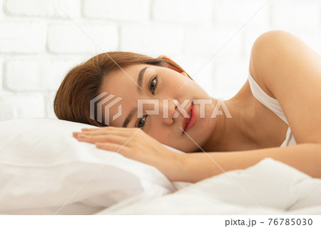 Asian women wake up happy and smile on white bed in bedroom. Asian women wake up happy and smile on white bed in bedroom. 76785030
