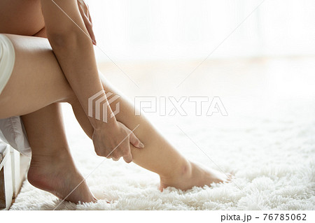 Asian women lag pain on bed in bed room in the morning. 76785062