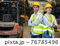 Two young asian engineers in uniform and a helmet stood and hugged their chests and looked at the camera at the auto parts factory in industrial Business concept. 76785496