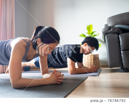 asian woman workout fitness elbow plank pose body weight home exercise yoga health training with trainer sport healthy lifestyle activity wellness care on mat indoors natural light selective focus asian woman workout fitness elbow plank pose body weight home exercise yoga health training with trainer sport healthy lifestyle activity wellness care on mat indoors natural light selective focus 76786792