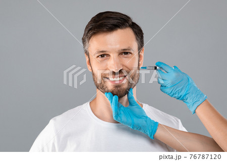 Unrecognizable cosmetician injecting face filler for middle-aged man 76787120