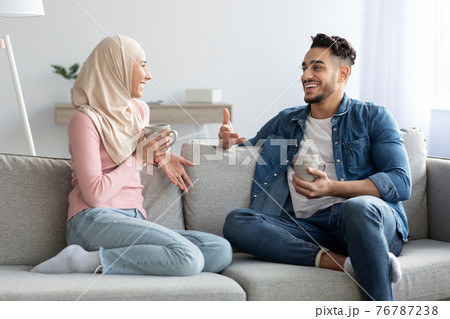 Young muslim couple drinking tea and talking at home 76787238
