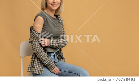 Lady getting vaccinated immunity to covid-19, recommended inoculation, coronavirus program, beige background Lady getting vaccinated immunity to covid-19, recommended inoculation, coronavirus program, beige background 76788493