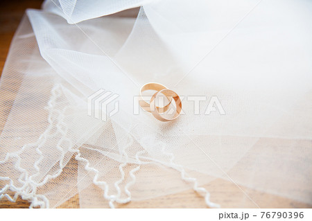Gold wedding rings on a white veil Gold wedding rings on a white veil 76790396