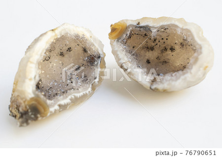 Druse of natural mineral agate. Closeup photo. Couple of beige crystals with black small inclusions. 76790651