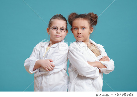 Two little girls in white coats 76790938