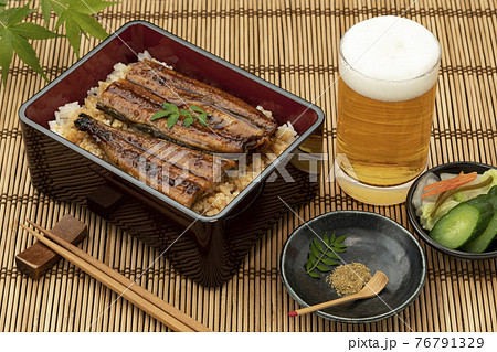 竹マットに置いた鰻重とビールと青もみじ 76791329