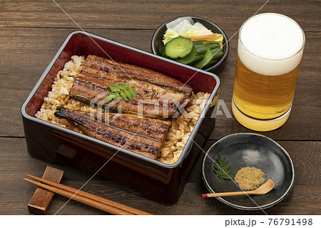 木目のテーブルに置いた鰻重とビール 76791498