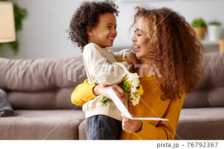 Young mixed race woman getting congratulations from son on Mothers day Young mixed race woman getting congratulations from son on Mothers day 76792367