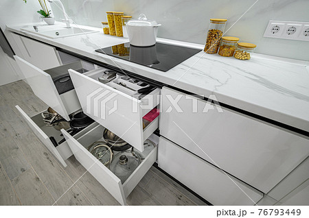 Luxurious white and black modern kitchen interior, drawers pulled out Luxurious white and black modern kitchen interior, drawers pulled out 76793449
