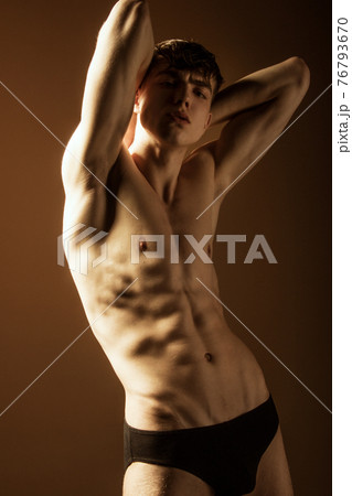 Muscle strong beautiful stripped male model in black jeans on black isolated font background 76793670