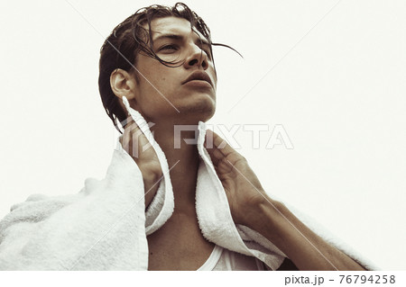 Sexy beautiful striped male model with white towel on the nature background with sand and sky on the beach on the sunset Sexy beautiful striped male model with white towel on the nature background with sand and sky on the beach on the sunset 76794258