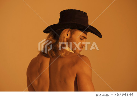 Sexy sport muscle strongface blond guy with long hair in cowbow hat on orange yellow isolated  font background 76794344