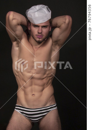 Sexy sport muscle strongface blond guy with long hair in white underwear on black isolated font background Sexy sport muscle strongface blond guy with long hair in white underwear on black isolated font background 76794356