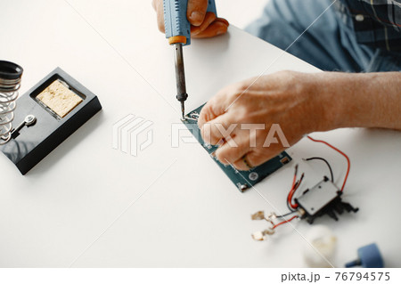 Male tech repairs electronic equipment at home Male tech repairs electronic equipment at home 76794575