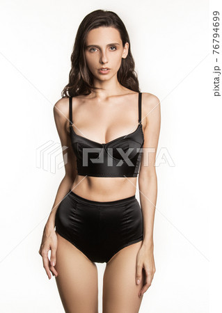 Stunning beautiful dark hair girl stripped in lingerie on white isolated font background Stunning beautiful dark hair girl stripped in lingerie on white isolated font background 76794699