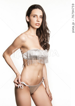 Stunning beautiful dark hair girl stripped in lingerie on white isolated font background Stunning beautiful dark hair girl stripped in lingerie on white isolated font background 76794759