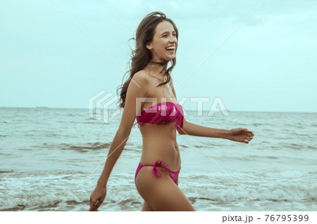Stunning beautiful dark hair girl stripped in swimsuit on the sunset at he beach 76795399
