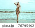 Stunning beautiful dark hair girl stripped in swimsuit on the sunset at he beach 76795402