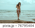 Stunning beautiful dark hair girl stripped in swimsuit on the sunset at he beach 76795404