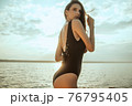 Stunning beautiful dark hair girl stripped in swimsuit on the sunset at he beach 76795405
