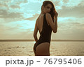 Stunning beautiful dark hair girl stripped in swimsuit on the sunset at he beach 76795406