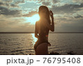 Stunning beautiful dark hair girl stripped in swimsuit on the sunset at he beach 76795408
