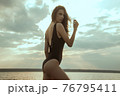 Stunning beautiful dark hair girl stripped in swimsuit on the sunset at he beach 76795411
