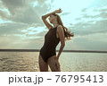 Stunning beautiful dark hair girl stripped in swimsuit on the sunset at he beach 76795413