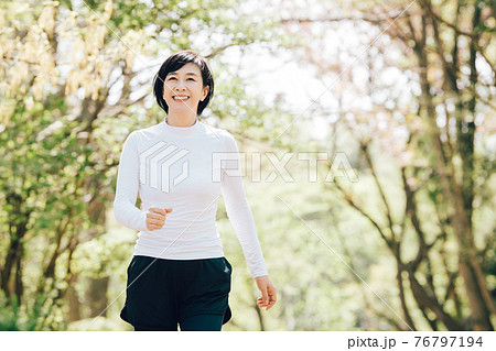ジョギング・ランニングをする50代の女性・健康イメージ 76797194