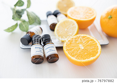 アロマオイルの瓶とフルーツ オレンジとレモン の写真素材