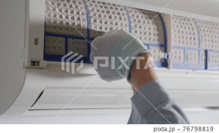 Hand of technician man working pulling dusty filter from air conditioner 76798819