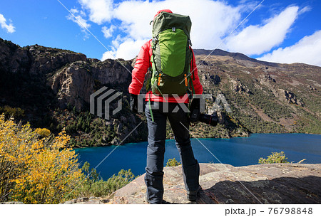 Woman photographer with camera in beautiful high altitude winter mountains 76798848