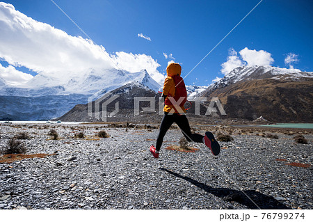 Woman trail runner cross country running in high altitude winter nature 76799274