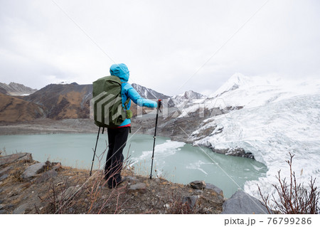 Successful woman backpacker hiking in winter mountains Successful woman backpacker hiking in winter mountains 76799286