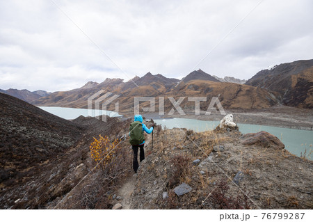 Successful woman backpacker hiking in winter mountains Successful woman backpacker hiking in winter mountains 76799287