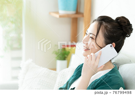 スマホで通話する若い女性 76799498