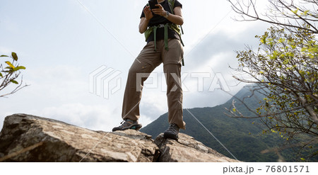 Successful woman looking at the view on high altitude mountain top 76801571
