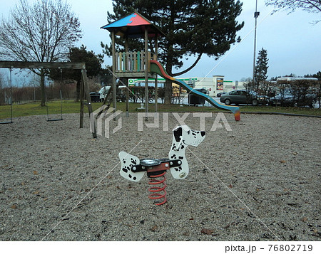 犬型の遊具とブランコと滑り台のある公園の写真素材