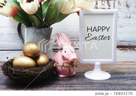 Happy Easter with flower, rabbit and easter eggs decoration on wooden background 76803270