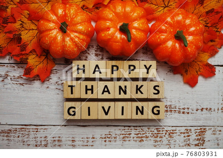 Happy Thanksgiving alphabet letter with pumpkins and autumn leaves on wooden background Happy Thanksgiving alphabet letter with pumpkins and autumn leaves on wooden background 76803931