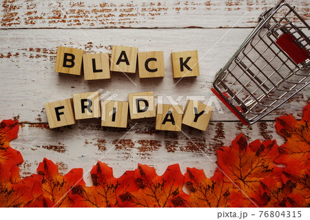 Black Friday alphabet letter and autumn leaves on wooden background 76804315