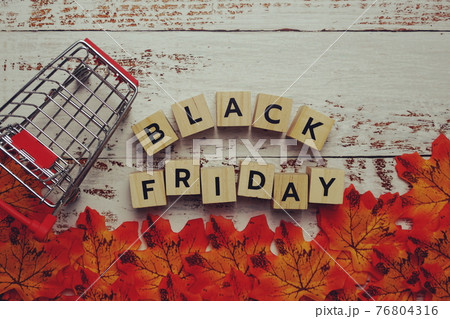 Black Friday alphabet letter and autumn leaves on wooden background 76804316