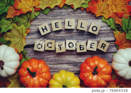 Hello October alphabet letter with pumpkin and maple leaves decoration on wooden background 76804338
