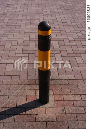 レンガ風敷石舗装上の車止めポールの写真素材 レンガ風敷石舗装上の車止めポールの写真素材