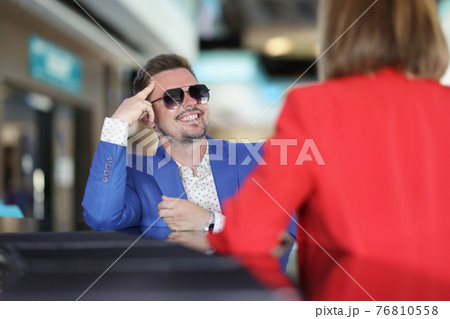 Smiling stylish man in sunglasses sitting at bar counter with woman Smiling stylish man in sunglasses sitting at bar counter with woman 76810558